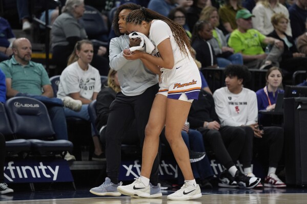Phoenix Mercury guard Haley Jones (30) is helped off the court after sustaining an injury during the second half of a WNBA basketball game against the Minnesota Lynx, Tuesday, June 3, 2025, in Minneapolis. (AP Photo/Abbie Parr)