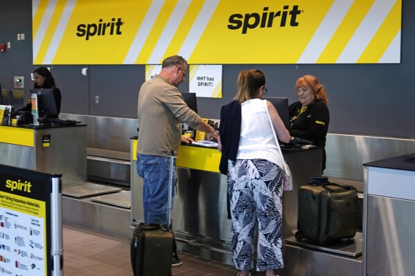 Travelers check in at the Spirit Airlines ticket counter at Manchester Boston Regional Airport, Friday, June 2, 2023, in Manchester, N.H. On Tuesday, the Conference Board reports on U.S. consumer confidence for July. (AP Photo/Charles Krupa)