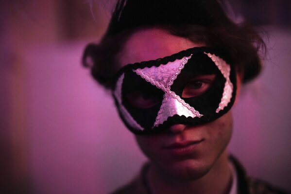 A costumed guest attends the Great Masked Ball in the Orangerie of the Versailles castle, outside Paris, Sunday, June 22, 2025. (AP Photo/Christophe Ena)