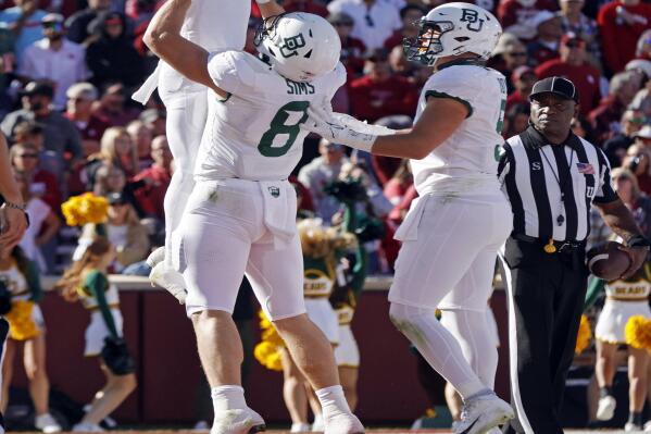 Baylor running back Craig Williams, top left, is lifted by tight end Ben Sims next to linebacker Dillon Doyle, right, after Williams scored a touchdown against Oklahoma in the first half of an NCAA college football game, Saturday, Nov. 5, 2022, in Norman, Okla. (AP Photo/Nate Billings)