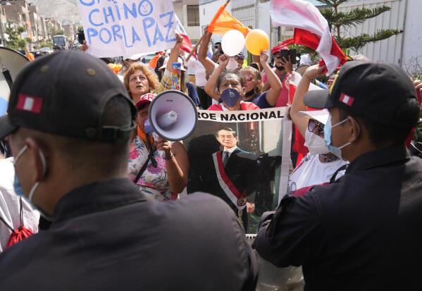 Supporters of former, jailed Peruvian President Alberto Fujimori gather outside the DIROES prison as they wait for his release, in Lima, Peru, Wednesday, March 30, 2022. Earlier in the month, Peru's Constitutional Court approved Fujimori's release from prison where he was serving a 25-year sentence for murder and corruption charges, restoring a humanitarian pardon granted to Fujimori on Christmas Eve in 2017. (AP Photo/Martin Mejia)