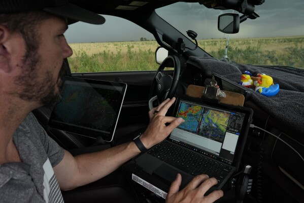 Victor Gensini, Northern Illinois University meteorology professor and a lead scientist of Project ICECHIP, checks storm data in the command vehicle during an operation Tuesday, June 3, 2025, south of Tipton, Okla.(AP Photo/Carolyn Kaster)