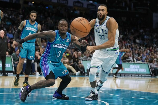 Charlotte Hornets guard Terry Rozier vies for the ball with Minnesota Timberwolves center Rudy Gobert during the second half of an NBA basketball game Saturday, Dec. 2, 2023, in Charlotte, N.C. (AP Photo/Chris Carlson)