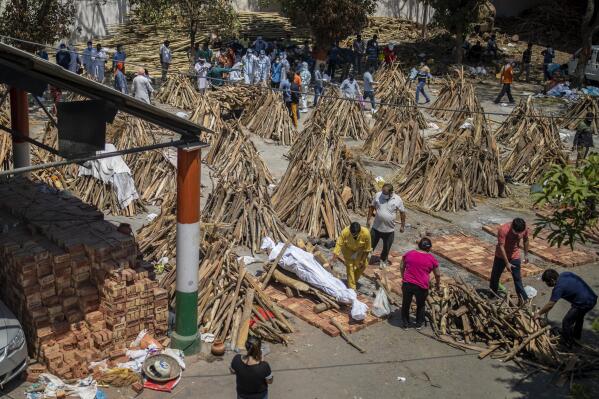 People prepare a funeral pyre for a family member who died of COVID-19 at a ground that has been converted into a crematorium for mass cremation of COVID-19 victims in New Delhi, India, Saturday, April 24, 2021. Indian authorities are scrambling to get medical oxygen to hospitals where COVID-19 patients are suffocating from low supplies. The effort Saturday comes as the country with the world’s worst coronavirus surge set a new global daily record of infections for the third straight day. The 346,786 infections over the past day brought India’s total past 16 million. (AP Photo/Altaf Qadri)
