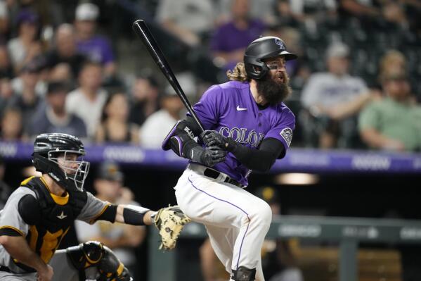 Colorado Rockies' Charlie Blackmon watches his RBI single next to Pittsburgh Pirates catcher Jason Delay during the eighth inning of a baseball game Friday, July 15, 2022, in Denver. (AP Photo/David Zalubowski)