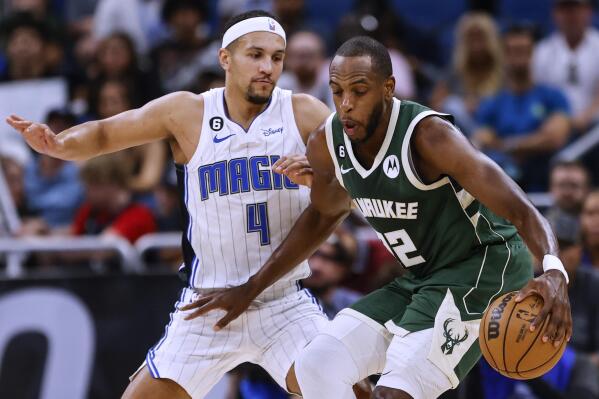 Orlando Magic guard Jalen Suggs (4) defends against Milwaukee Bucks forward Khris Middleton (22) during the first half of an NBA basketball game Tuesday, March 7, 2023, in Orlando, Fla. (AP Photo/Kevin Kolczynski)
