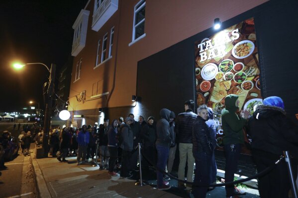 
              An estimated 400 people were in line to purchase cannabis at the Tweed retail store on Water Street, in St. John's, Newfoundland and Labrador, when it became legal after midnight on Wednesday, Oct. 17, 2018. Newfoundland and Labrador regulations have the store closing at 2:00 a.m. local time. (Paul Daly/The Canadian Press via AP)
            