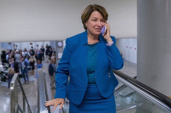 File - Sen. Amy Klobuchar of Minnesota talks on the phone as she walks to a vote on Capitol Hill, Sept. 6, 2023 in Washington. Klobuchar and Rep. Yvette Clarke of New York sent a letter Thursday to Meta CEO Mark Zuckerberg and X CEO Linda Yaccarino asking each to explain any rules they're crafting to curb AI-generated election ads that deceive people. (AP Photo/Alex Brandon, File)