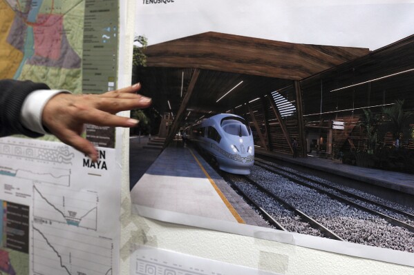 FILE - Rogelio Jiménez Pons, director of Fonatur, points to photos of a planned train through the Yucatan Peninsula, during an interview in Mexico City, March 18, 2019. Mexico’s President Andrés Manuel López Obrador is in a rush to finish the big legislative and building projects he promised before his term ends in September 2024, chief among the projects are railway lines, like the Mayan Train. (AP Photo/Marco Ugarte, File)