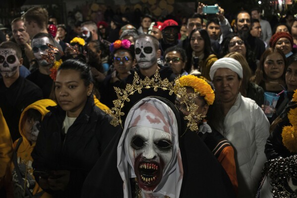 People wearing masks attend a Muerteada parade in San Jose, Mexico, Thursday, Nov. 2, 2023. Mexicans in the Oaxacan town celebrate the traditional Muerteada, a theatrical recreation that is performed through the night of November 1 until the early morning of the following day, with dances and music parading through the streets, while telling the story of how a deceased person is resurrected with the help of a priest, a doctor and a spiritist. (AP Photo/Maria Alferez)