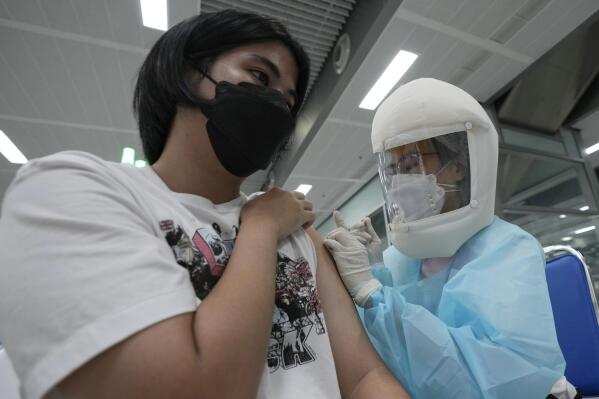 A health worker administers a dose of the AstraZeneca COVID-19 vaccine at the Central Vaccination Center in Bangkok, Thailand, Thursday, July 15, 2021. As many Asian countries battle against a new surge of coronavirus infections, for many their first, the slow-flow of vaccine doses from around the world is finally picking up speed, giving hope that low inoculation rates can increase rapidly and help blunt the effect of the rapidly-spreading delta variant. (AP Photo/Sakchai Lalit)