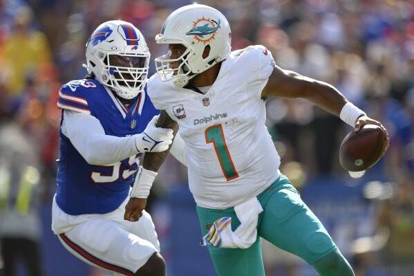 Buffalo Bills defensive end Kingsley Jonathan, left, gets a grip on Miami Dolphins quarterback Tua Tagovailoa, right, during the second half an NFL football game, Sunday, Oct. 1, 2023, in Orchard Park, N.Y. (AP Photo/Adrian Kraus)