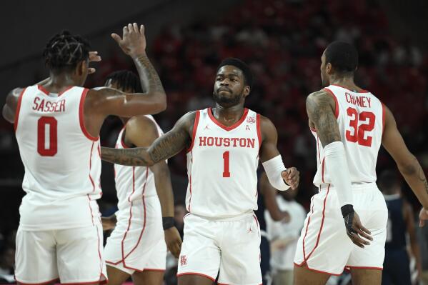 =Houston guard Jamal Shead (1) is congratulated by teammates after his dunk against Rice during the first half of an NCAA college basketball game Friday, Nov. 12, 2021, in Houston. (AP Photo/Justin Rex)