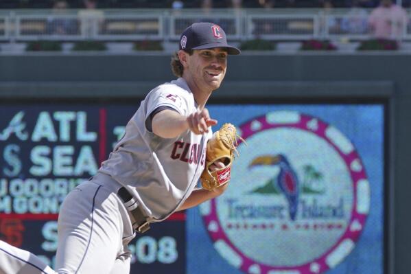 Cleveland Guardians pitcher Shane Bieber smiles on his follow-through against the Minnesota Twins in the fifth inning of a baseball game, Sunday, Sept 11, 2022, in Minneapolis. (AP Photo/Jim Mone)