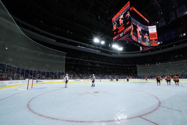 Players skate off the ice after a power outage during the second period of a preseason NHL hockey game between the Philadelphia Flyers and the Washington Capitals, Saturday, Oct. 2, 2021, in Philadelphia. (AP Photo/Matt Slocum)