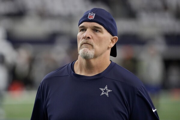 FILE - Dallas Cowboys defensive coordinator Dan Quinn watches players warm up for an NFL football game against the Washington Commanders on Nov. 23, 2023, in Arlington, Texas. Quinn was the 12th candidate to interview for the Los Angeles Chargers head coach opening. Quinn just completed his third season with the Cowboys. He was the Falcons head coach for five-plus seasons (2015-20), where he went 43-42 with a Super Bowl berth after the 2016 season. (AP Photo/Sam Hodde, File)