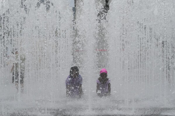 Children cool themselves off in a public fountain in Seoul, South Korea, Thursday, July 25, 2024. A heat wave warning was issued in Seoul as temperatures soared 33 degrees Celsius (91.4 degrees Fahrenheit). (ĢӰԺ Photo/Ahn Young-joon)