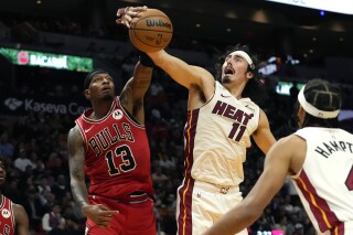Chicago Bulls forward Torrey Craig (13) and Miami Heat guard Jaime Jaquez Jr. (11) go for the ball during the second half of an NBA basketball game, Thursday, Dec. 14, 2023, in Miami. (AP Photo/Lynne Sladky)