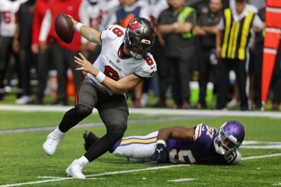 Tampa Bay Buccaneers quarterback Baker Mayfield (6) runs from Minnesota Vikings linebacker Benton Whitley (51) during the first half of an NFL football game, Sunday, Sept. 10, 2023, in Minneapolis. (AP Photo/Bruce Kluckhohn)