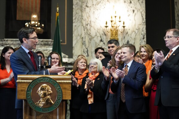 FILE -Washington Attorney General Bob Ferguson introduces Sen. Jamie Pedersen, D-Seattle, second from right, after making remarks Tuesday, April 25, 2023, at the Capitol in Olympia, Wash. A federal judge on Friday, March 8, 2024 rejected a challenge to a Washington state law that cleared the way for lawsuits against the gun industry in certain cases. The measure was one of three bills signed by Democratic Gov. Jay Inslee last year seeking to address gun violence. (AP Photo/Lindsey Wasson, File)