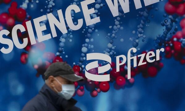 FILE - A man walks by Pfizer headquarters, Friday, Feb. 5, 2021 in New York. On Friday, May 27, 2022 The Associated Press reported on stories circulating online incorrectly claiming Pfizer received FDA approval for a new monkeypox shot the day after the U.S. purchased millions of dollars worth of vaccine for the disease. (AP Photo/Mark Lennihan)
