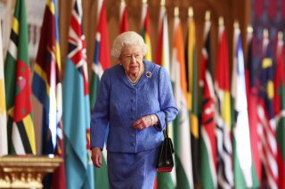 Britain's Queen Elizabeth II walks past Commonwealth flags in St George's Hall at Windsor Castle, England to mark Commonwealth Day in this image that was issued on Saturday March 6, 2021. The timing couldn’t be worse for the Queen's grandson Harry and his wife Meghan. The Duke and Duchess of Sussex will finally get the chance to tell the story behind their departure from royal duties directly to the public on Sunday, when their two-hour interview with Oprah Winfrey is broadcast. (Steve Parsons/Pool via AP)
