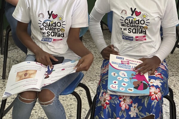 Teenage club members wear shirts that reads in Spanish "I take care of my body and my heath" at a session on sex education at a school on the weekend in Azua, Dominican Republic, Saturday, Dec. 9, 2023. To help girls prevent unplanned pregnancies in a country where abortion is illegal, activists have developed “teenage clubs,” where adolescents learn about sexual and reproductive rights, self-esteem, gender violence, finances and other topics. (AP Photo/Maria Hernandez)