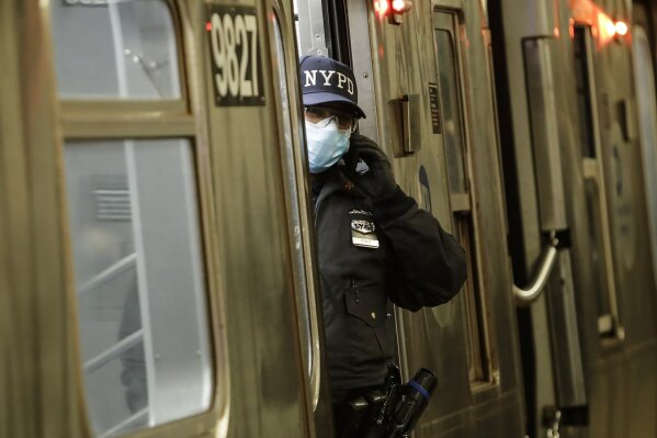 A New York Police officer helps to clear a train at the Coney Island Stillwell Avenue Terminal, Tuesday, May 5, 2020, in the Brooklyn borough of New York. (AP Photo/Frank Franklin II)