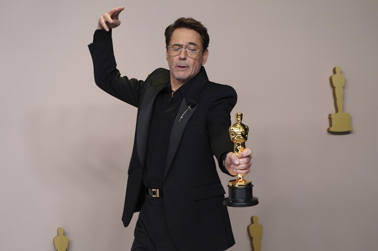 Robert Downey Jr. poses with the award for best performance by an actor in a supporting role for 