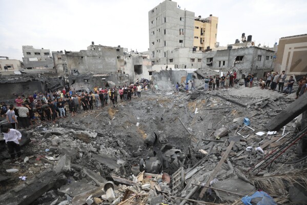 FILE - Palestinians inspect the rubble of a destroyed building after an Israeli airstrike in Deir al Balah, Gaza Strip on Oct. 27, 2023. U.N. humanitarian monitors say at least 2,700 people, including 1,500 children, are missing and believed buried under the rubble. (APPhoto/Ali Mahmoud, File)