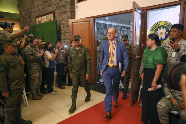 Philippines' military Chief Gen. Romeo Brawner Jr., center left, and US Embassy Chargé d' Affaires, Robert Ewing, center right, arrive during the opening ceremonies of the "Balikatan" or Shoulder-to-Shoulder at Camp Aguinaldo military headquarters in Quezon City, Philippines on Monday April 22, 2024. (AP Photo/Basilio Sepe)