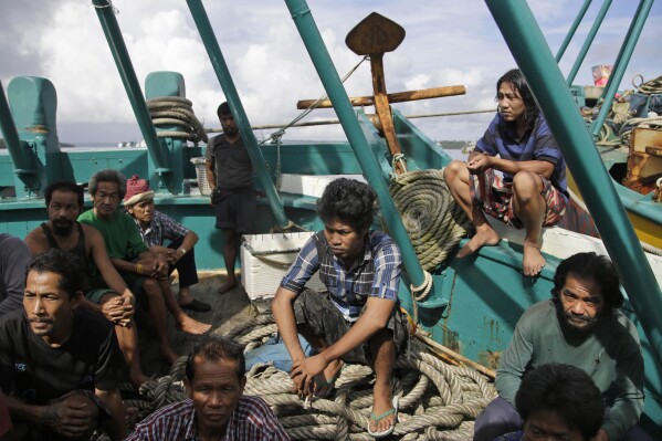 Foreign fishermen gather on their boat during an inspection conducted by Indonesian officials in Benjina, Aru Islands, Indonesia, Friday, April 3, 2015. Officials from three countries are traveling to remote islands in eastern Indonesia to investigate how thousands of foreign fishermen were abused and forced into catching seafood that could end up in the United States, Europe and elsewhere. (AP Photo/Dita Alangkara)