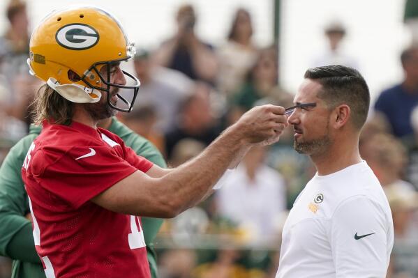 Green Bay Packers' Aaron Rodgers takes head coach Matt LaFleur's sun glasses at the NFL football team's practice field Wednesday, July 27, 2022, in Green Bay, Wis. (AP Photo/Morry Gash)
