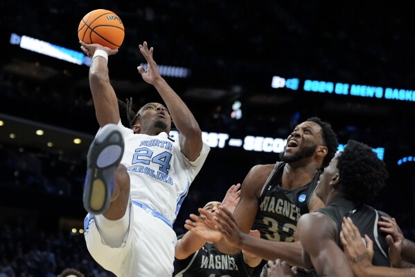 North Carolina forward Jae'Lyn Withers shoots over Wagner forward Keyontae Lewis (32) during the first half of a first-round college basketball game in the NCAA Tournament, Thursday, March 21, 2024, in Charlotte, N.C. (AP Photo/Chris Carlson)