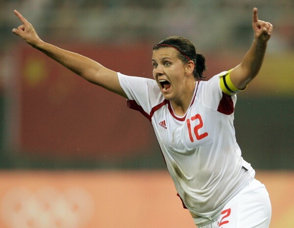 FILE - Canada's Christine Sinclair celebrates after she scored a goal against China during a Beijing 2008 Olympics Group E women's first round soccer match in Tianjin, China, Saturday, Aug. 9, 2008. Sinclair, the top goal scorer in international soccer, has announced she will retire from the Canadian national team at the end of this season. Sinclair, 40, announced her decision Thursday night, Oct. 19, 2023, on Instagram in a video that showed a pair of cleats swinging in the breeze on a goal.(AP Photo/Vincent Yu, File)
