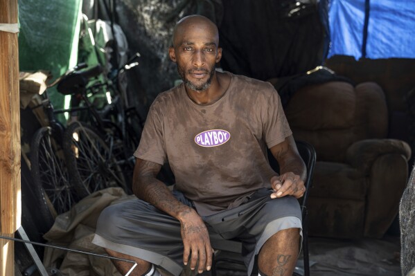 Stefon James Dewitt Livengood poses for a portrait in the tent where he lives in Phoenix on July 23, 2023. Livengood is experiencing homelessness while living through a record breaking heat wave. (AP Photo/Thomas Machowicz)