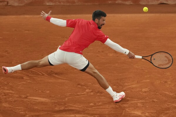 Serbia's Novak Djokovic returns the ball to Mackenzie McDonald of the U.S. during their first round match of the French Tennis Open, at the Roland-Garros stadium, in Paris, Tuesday, May 27, 2025. (AP Photo/Thibault Camus)