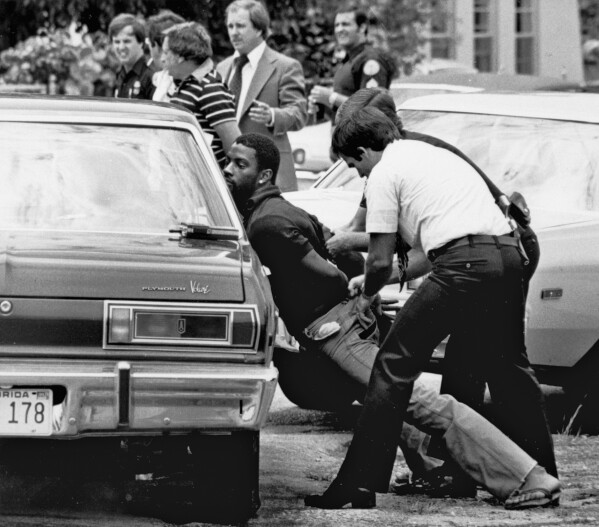 FILE - Police handcuff a suspect during a drug raid in Miami, May 18, 1979. Police said eight were arrested and marijuana was seized. (AP Photo/Al Diaz, File)