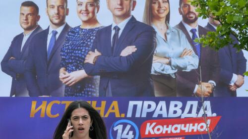 A woman walks past a pre-election billboard showing pro-Serbian and Russian coalition called "For the Future of Montenegro" in Podgorica, Montenegro, Friday, June 9, 2023. Montenegro is holding an early parliamentary election Sunday, a vote that could provide indications of whether the small NATO member in the Balkans will overcome the deep political divisions and instability that have hampered its route to joining the European Union. (AP Photo/Risto Bozovic)