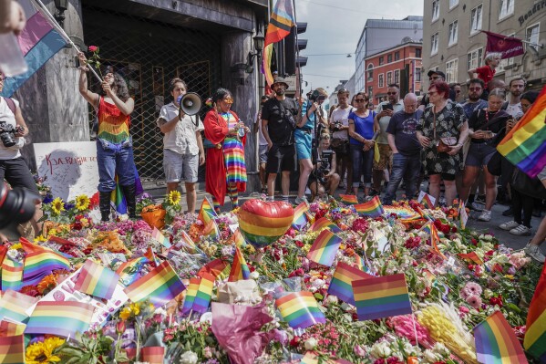 FILE - Flowers are left as a spontaneous pride parade arrives at the scene of a shooting in central Oslo, Saturday, June 25, 2022. Threats have increased against next week's LGBTQ+ Pride festival in Oslo following a deadly shooting last year at the annual event, the Norwegian Police Security Service said Wednesday, June 21, 2023. (Håkon Mosvold Larsen/NTB Scanpix via AP, File)