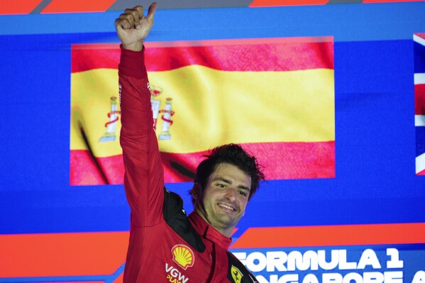 Ferrari driver Carlos Sainz of Spain celebrates on the podium after winning the Singapore Formula One Grand Prix at the Marina Bay circuit, Singapore,Sunday, Sept. 17, 2023. (AP Photo/Vincent Thian)