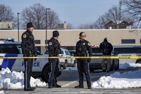 FILE - Law enforcement officers stand outside a school housing educational program Starts Right Here following a shooting, Jan. 23, 2023, in Des Moines, Iowa. The families of two teenagers shot to death in the Des Moines alternative school have filed a lawsuit Monday, May 15, alleging the program and its founder were negligent in not keeping the premises safe. (Zach Boyden-Holmes/The Des Moines Register via AP, File)