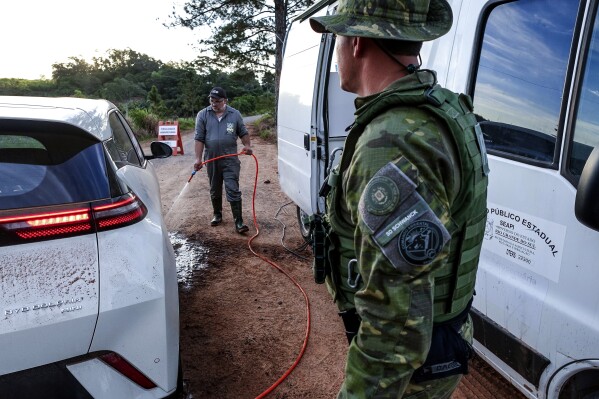 Health and safety agents set up disinfection barriers to contain the first confirmed case of bird flu in commercial poultry, in the municipality of Montenegro, Rio Grande do Sul state, Brazil, Saturday, May 17, 2025. (AP Photo/Wesley Santos)