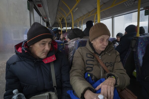 Refugees in a bus go to a railway station to evacuate to western Ukraine as they run from Russian offensive in the Donetsk region, in Pavlohrad, Dnipropetrovsk region, Ukraine, Thursday, Dec. 12, 2024. (AP Photo/Efrem Lukatsky)