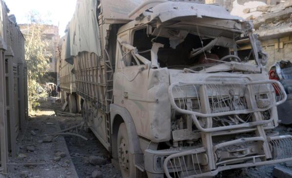 In this photo released by the Syrian official news agency SANA, shows a truck damaged after an explosion hit a building, in Deir el-Zour, Syria, Wednesday, March 8, 2023. An explosion in eastern Syria killed people, according to reports. A war monitoring group said the blast was likely caused by a drone strike that targeted Iran-backed militiamen.(SANA via AP)
