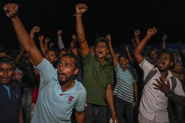 Sri Lankans celebrate as they react to early reports of President Gotabaya Rajapaksa's resignation in Colombo, Sri Lanka, Thursday, July 14, 2022. Embattled Rajapaksa fled a day earlier under pressure from demonstrators furious over the island nation’s economic collapse. He finally emailed his resignation Thursday, a day later than promised, according to an official. (AP Photo/Rafiq Maqbool)