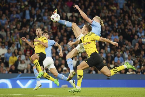 Manchester City's Erling Haaland, right, scores his side's 2nd goal during the group G Champions League soccer match between Manchester City and Borussia Dortmund at the Etihad stadium in Manchester, England, Wednesday, Sept. 14, 2022. (AP Photo/Dave Thompson)