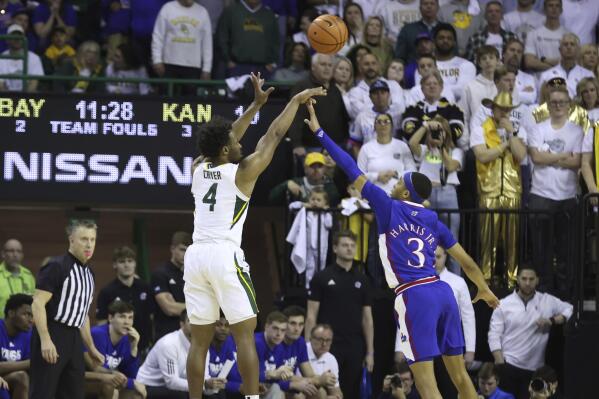 Baylor guard LJ Cryer (4) scores a 3-point basket over Kansas guard Dajuan Harris Jr. (3) during the first half of an NCAA college basketball game Monday, Jan. 23, 2023, in Waco, Texas. (AP Photo/Jerry Larson)