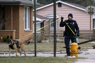 Manitowoc Police Officer Nick Place and K-9 dog Riley search for a missing 3-year-old along Bellevue Place near 43rd Street, Tuesday, Feb. 20, 2024, in Two Rivers, Wis. The mother of the Wisconsin boy who vanished nearly a week ago and a man her son was staying with were formally charged with child neglect Monday, Feb. 26, in connection with the boy's disappearance. (Gary C. Klein/The Sheboygan Press via AP)