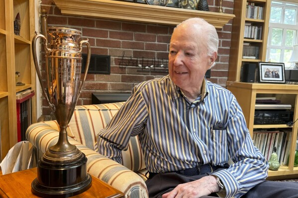 William Cashore, 84, smiles as he looks at his 1954 Scripps National Spelling Bee championship trophy, Wednesday, 29 May, 2024 in Greenwich, Rhode Island. As a 14-years-old Cashore correctly spelled the final two words of the contest, uncinated and transept, in 1954. (AP Photo/Rodrique Ngowi)